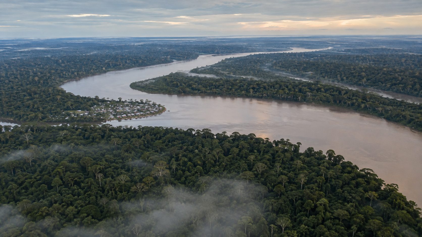 Vista aérea de um rio atravessando floresta densa ao amanhecer
